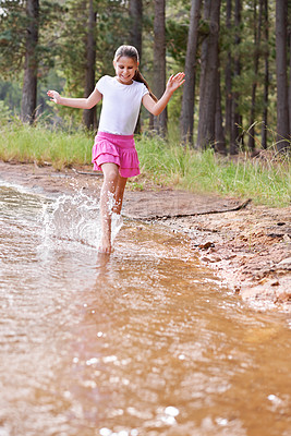 Buy stock photo A cute little girl running through a wilderness stream