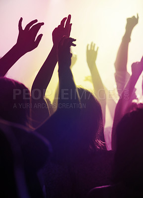 Buy stock photo Hands, dancing and fans at concert or music festival from back, neon light and energy at live event. Dance, fun and group of excited people in arena at rock band performance or audience at rave party