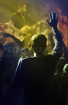 Buy stock photo Concert, singing and people dancing to music at night performance, rock and gen z singer in lights and cheers. Musician on stage at disco event and fans rear, crowd or audience with man hands in air