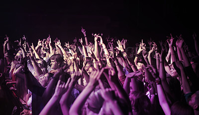 Buy stock photo Big crowd, hands and people at music festival or concert, neon lights and energy at live event. Dance, fun and excited fans dancing in arena at rock band performance or audience at weekend rave party