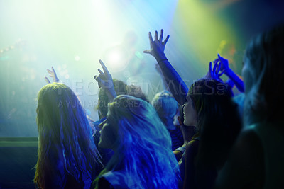 Buy stock photo Crowd, neon lights and people at concert or music festival dancing with energy and hands up at night event. Dance, fun and group of excited fans in arena at rock band performance or audience at party