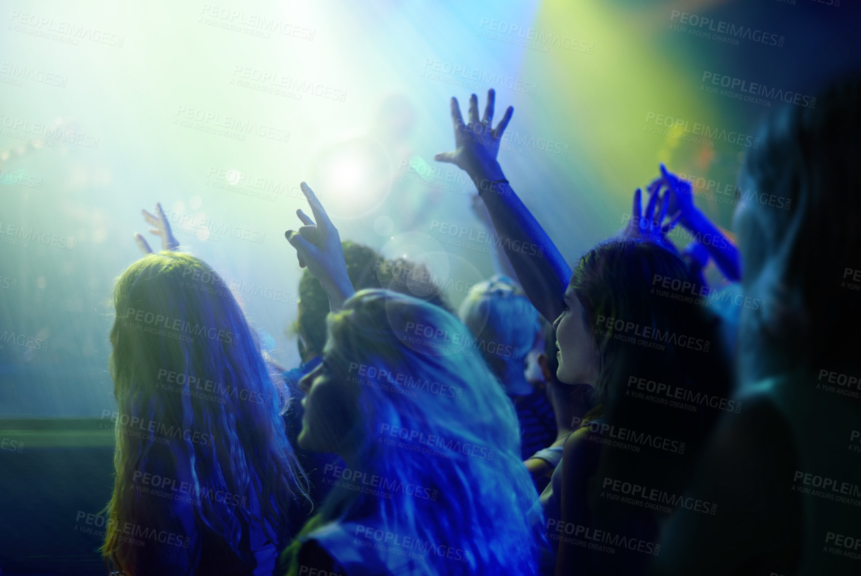 Buy stock photo Crowd, neon lights and people at concert or music festival dancing with energy and hands up at night event. Dance, fun and group of excited fans in arena at rock band performance or audience at party