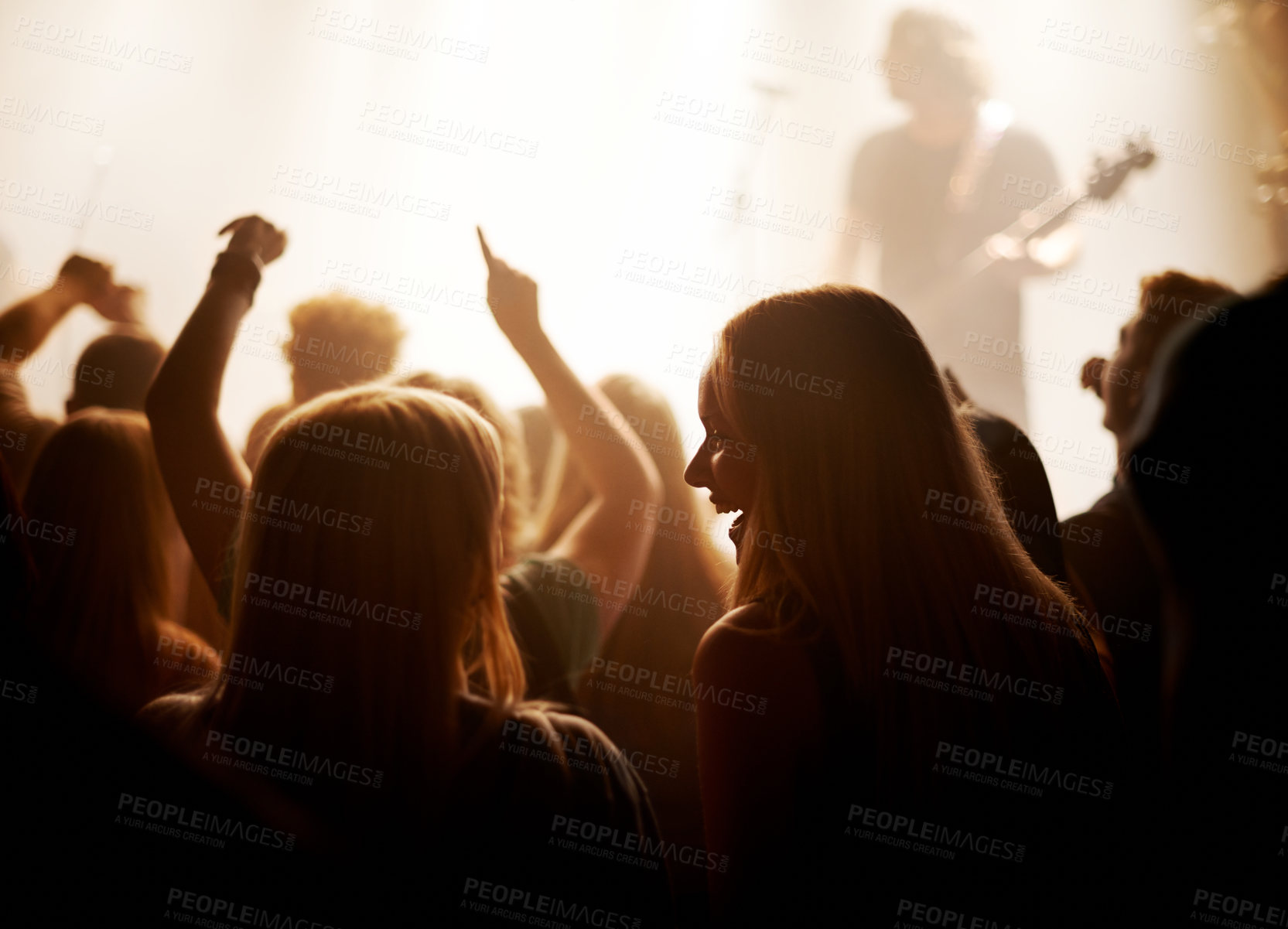 Buy stock photo Excited women, friends and fans at music festival, lights and crowd in silhouette at live band performance on stage. Happiness, people with smile and lighting, excitement at rock concert together.