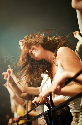 Buy stock photo Fence, dancing and woman in crowd at concert or music festival, happiness at rock event. Girl in audience, excited fan at live band performance in arena or stadium with dance and energy at night show