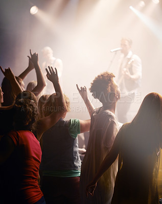 Buy stock photo People dancing, concert and singing music at night performance, gen z band singer with lights and cheers. Musician on stage at event and youth dance, crowd of fans or women audience with hands in air