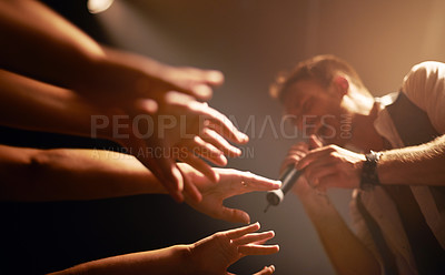 Buy stock photo Hands, fans at concert and musician at music festival with microphone on stage with front row crowd. Audience, excited people reach for singer and live band performance in arena with energy at show.