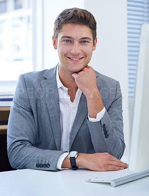 Buy stock photo A satisfied young businessman sitting at his desk