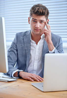 Buy stock photo A bored young businessman seated at his desk