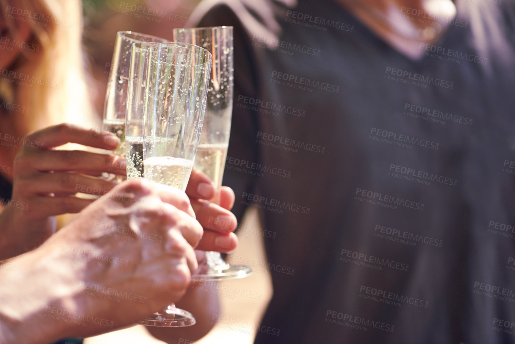Buy stock photo Cropped shot of people drinking champagne together in an outdoor setting