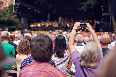 Buy stock photo Shot of a person in the crowd holding a camera to photograph a classical concert