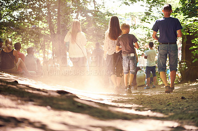 Buy stock photo Festival, party and family walking in forest outdoor together for event, celebration or social gathering. Mother, father and children in nature, park or woods for summer entertainment from back