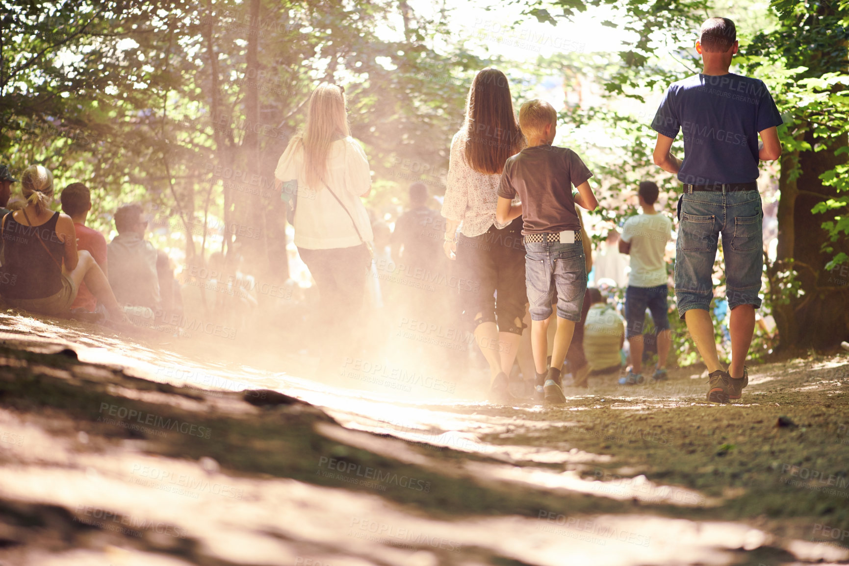 Buy stock photo Festival, party and family walking in forest outdoor together for event, celebration or social gathering. Mother, father and children in nature, park or woods for summer entertainment from back