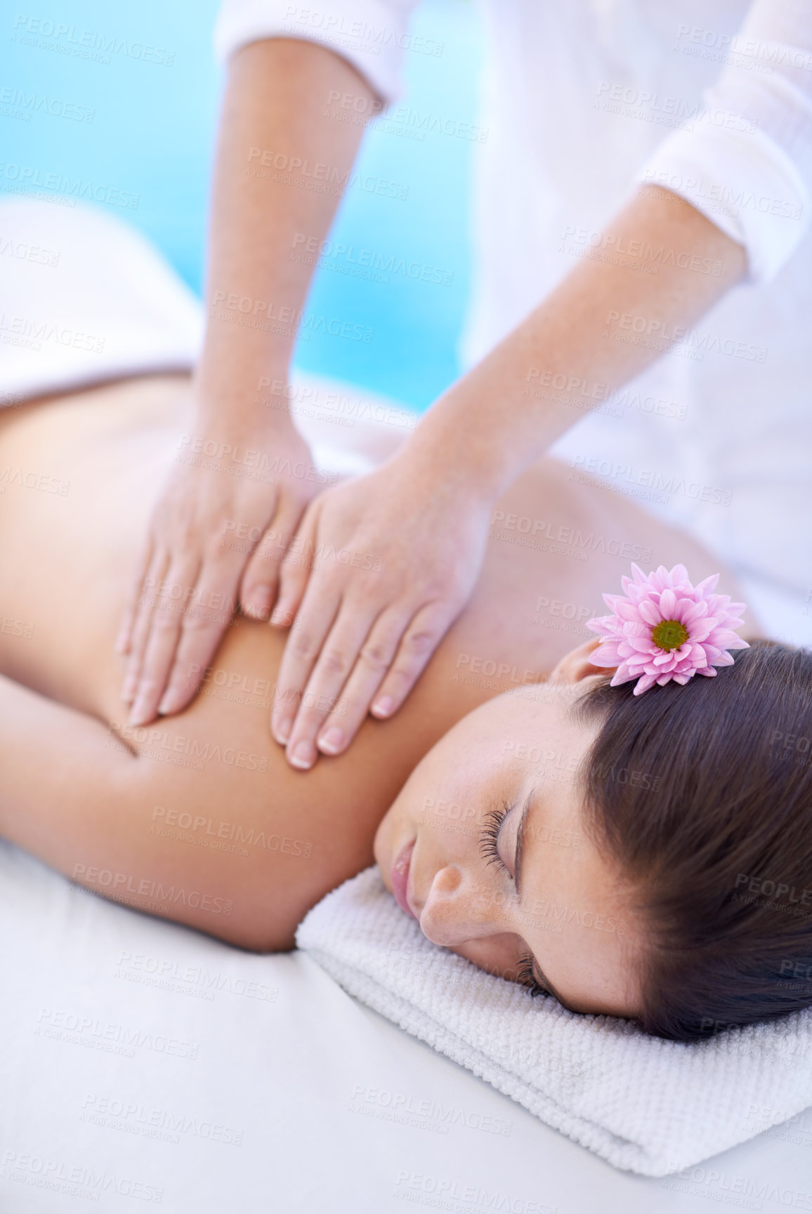 Buy stock photo Relax, massage and woman at hotel pool with flower for health, wellness and luxury holistic treatment. Self care, peace and girl on table with masseuse for body therapy, sleep and calm spa service