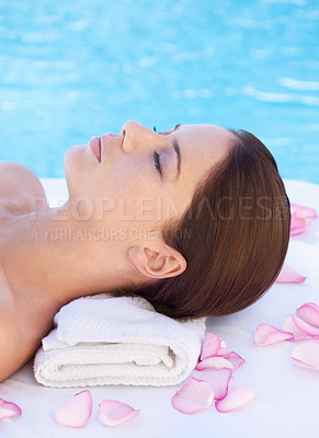 Buy stock photo Relax, massage and woman at luxury spa pool with petals for health, wellness balance and holistic treatment. Self care, peace and girl on poolside bed for body, comfort and calm hotel service