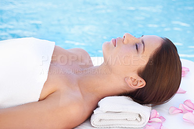 Buy stock photo Shot of a young woman relaxing by a pool at a spa