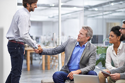 Buy stock photo Shot of a two business professionals shaking hands in an office