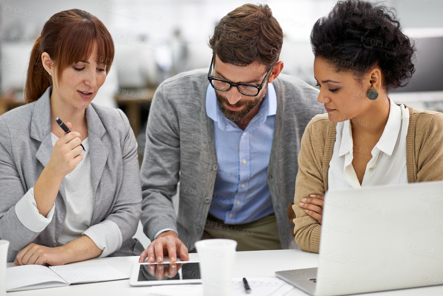 Buy stock photo Business people, tablet and discussion in meeting for planning, brainstorming or networking at office. Group of employees working with technology, laptop and notebook for team research at workplace