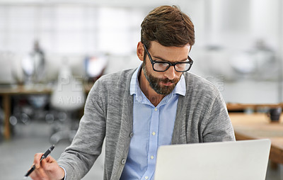 Buy stock photo A young businessman working on his laptop in the office