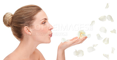 Buy stock photo An attractive young woman blowing rose petals against a white background