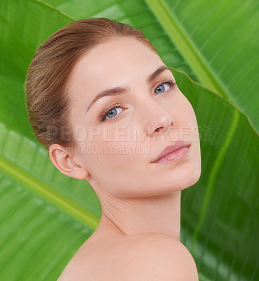 Buy stock photo Cropped portrait of a beautiful young woman against the backdrop of palm leaves