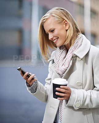 Buy stock photo Woman, smartphone and coffee in street, winter or texting with scarf, fashion or reading in city. Girl, person and phone on mobile app for notification on urban sidewalk for social media in Cape Town