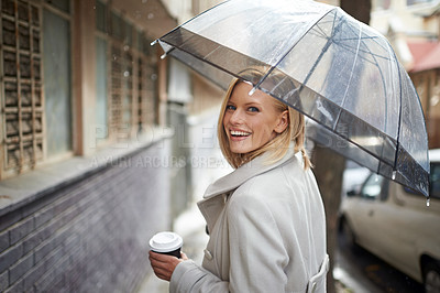 Buy stock photo Woman, umbrella and coffee in city with portrait, smile and walking for commute in winter rain. Person, trench coat and outdoor with fashion in metro street with coco, tea cup and happy in Cape Town