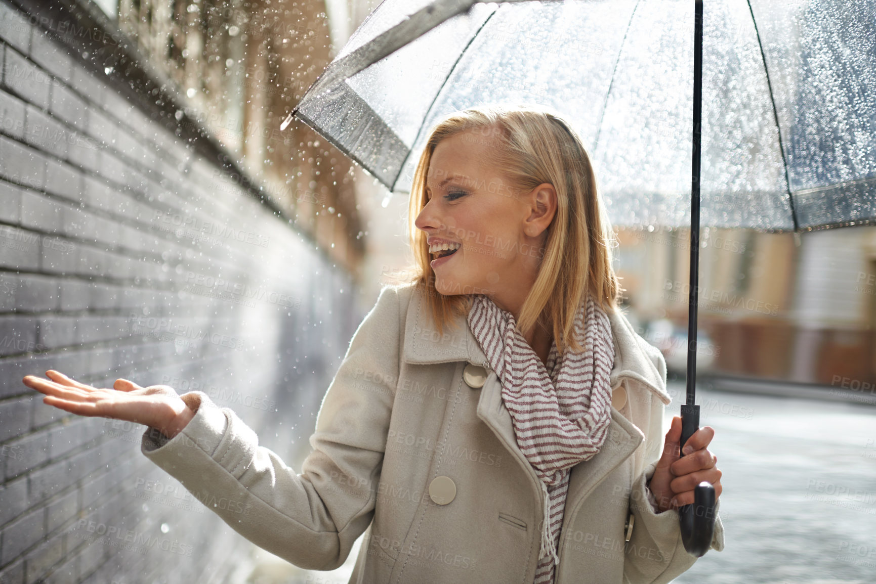 Buy stock photo Smile, happy woman and rain feel in the city with umbrella, freedom and happiness on holiday. Winter weather, raining and urban street with a young female person on a sidewalk and vacation outdoor