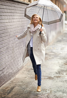 Buy stock photo Rain umbrella, city street and woman jump with happiness on a sidewalk from winter weather. Happy female person, raining and travel on urban road outdoor in Cape Town on holiday with freedom and joy