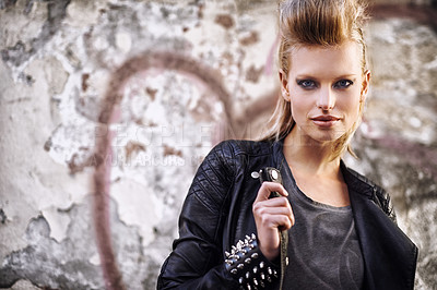 Buy stock photo Woman, portrait and confident in edgy fashion with punk rock hairstyle, biker and cool in funky clothes by graffiti wall. Young model, face and leather jacket in urban town with trendy by street art
