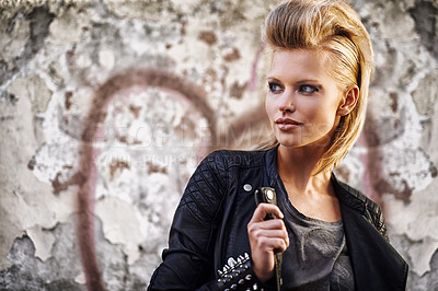 Buy stock photo An edgy young woman holding the collar of her leather jacket