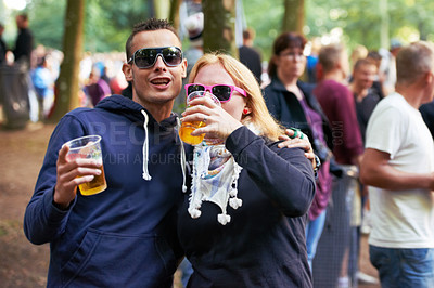 Buy stock photo Drinks, happy and couple of friends at music festival, concert or party for outdoor rave or techno celebration. Portrait of young people, audience or crow in forest with beer or alcohol for holiday