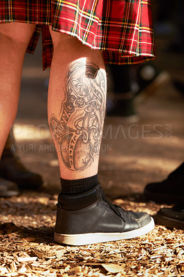 Buy stock photo Closeup, man and leg with tattoo, outdoor and festival with sneakers and weekend break. Person, outside and guy with a shoes and summer for fun and getaway trip with art and ground with sunshine