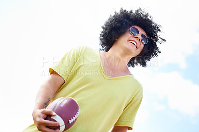 Buy stock photo Smile, sports and man playing football on blue sky from below for fitness, fun or recreation. Exercise, training and leisure with happy young person holding ball outdoor for game or match in summer