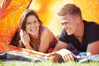 Buy stock photo Happy couple, tent and laughing for funny joke, humor or bonding together at outdoor campsite. Face of young man and woman with smile enjoying fun holiday weekend, vacation and camping on green grass