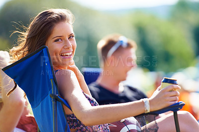 Buy stock photo Portrait of an attractive young woman having a beer while sitting with her friends at a campsite