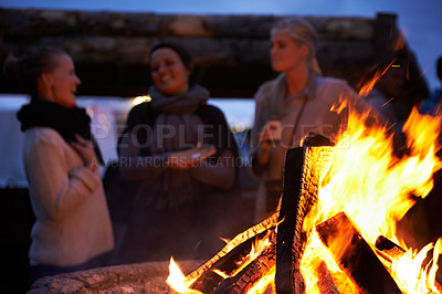 Buy stock photo Cropped shot of people standing around a fire