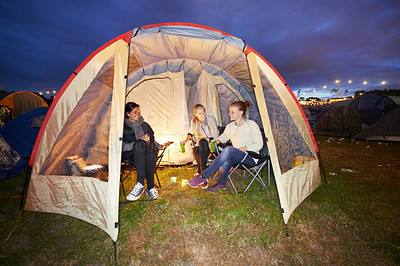 Buy stock photo Happy woman, friends and night in tent at festival for party, event or carnival on outdoor campsite. Female person, people or group in relax or camping in the late evening with drinks and candlelight