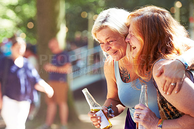 Buy stock photo Laughing, mature or friends with beer at music festival for concert or party on fun holiday together. Smile, women or happy people enjoying drinks, hug or carnival event on vacation in celebration 