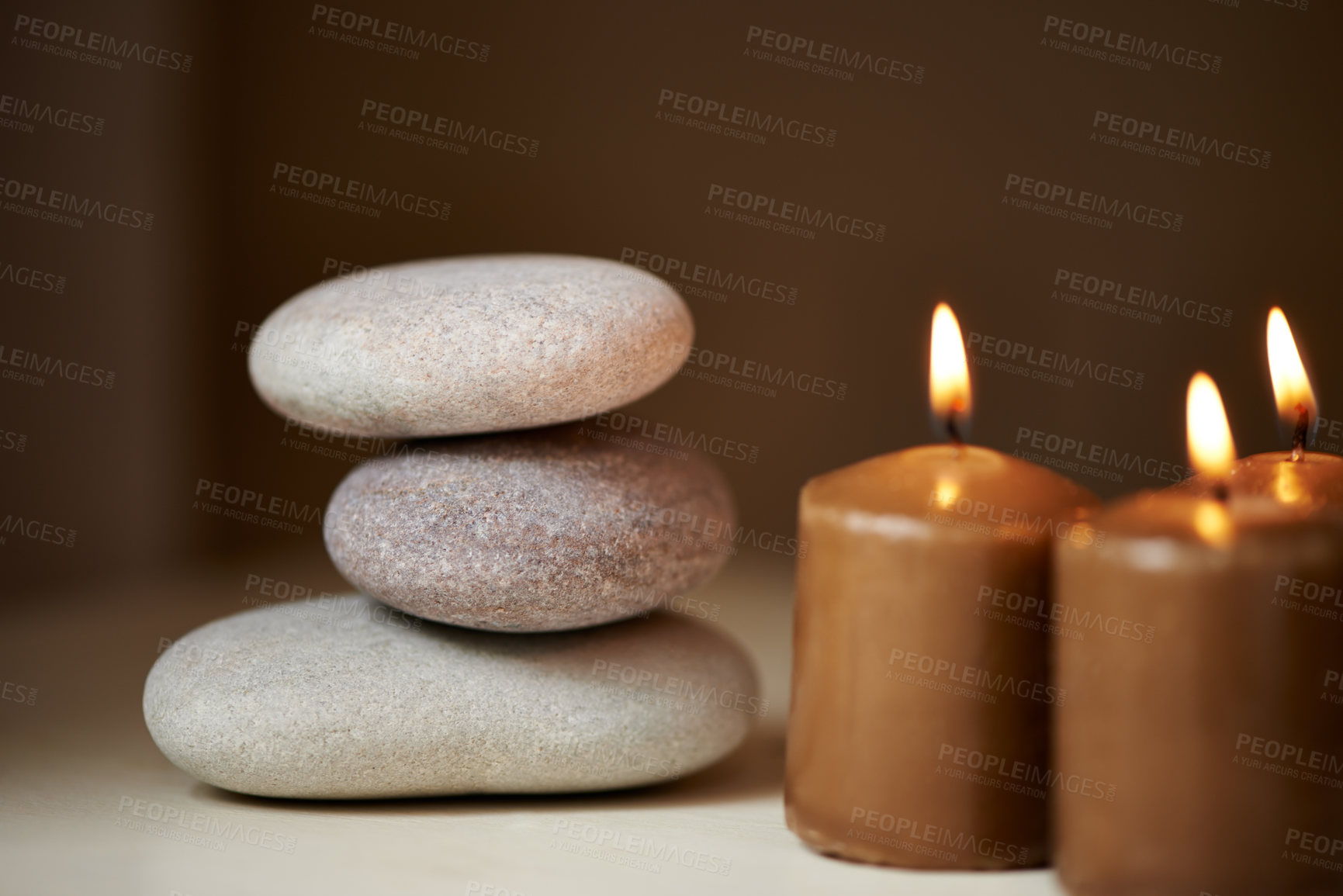 Buy stock photo Three stones balanced on top of each other alongside some candles