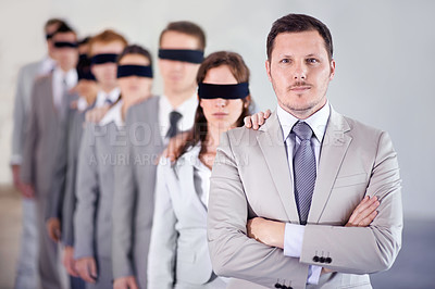 Buy stock photo Shot of a manager standing in front of a line of blindfolded employees