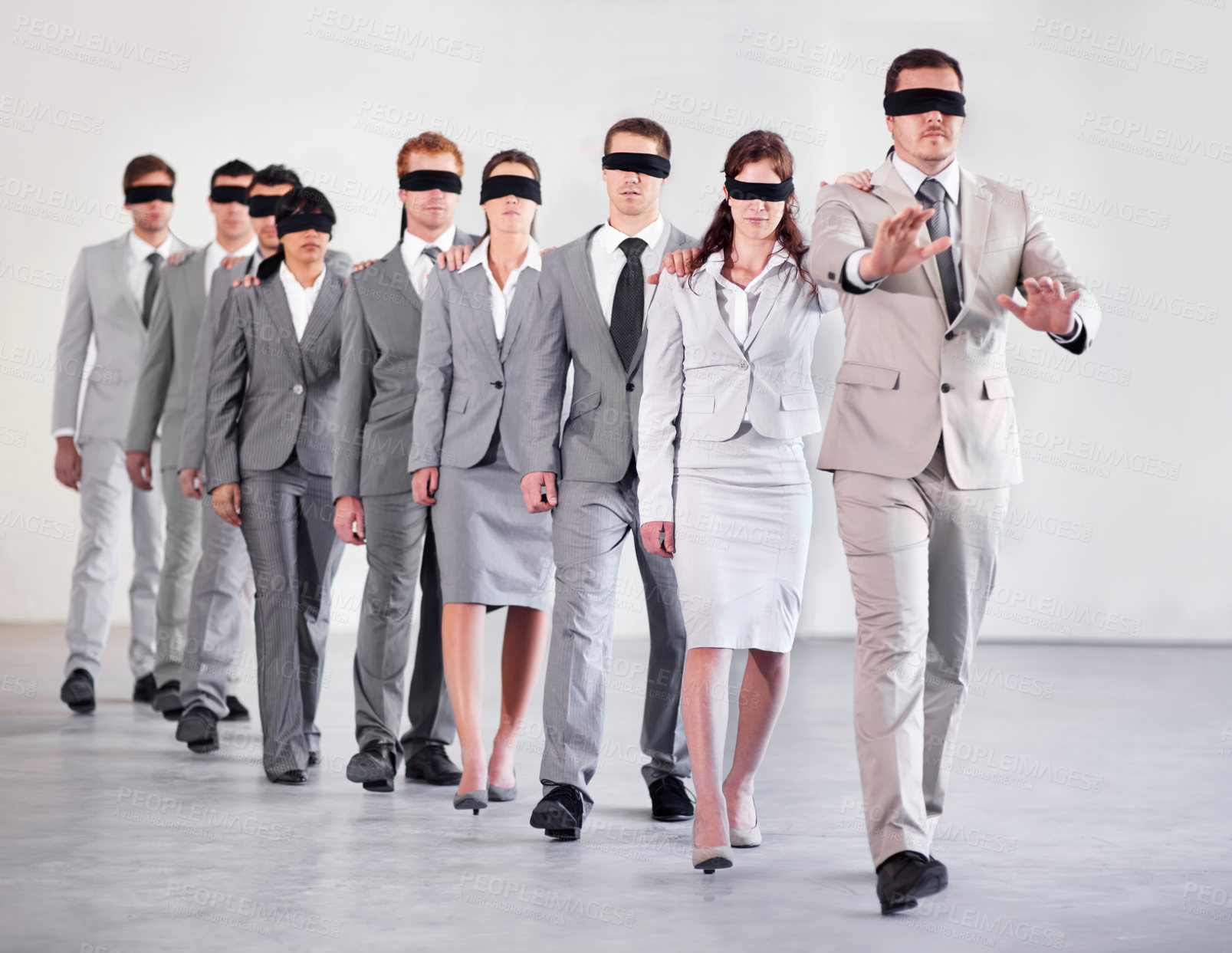 Buy stock photo Shot of a group of blindfolded businesspeople following their equally blind manager