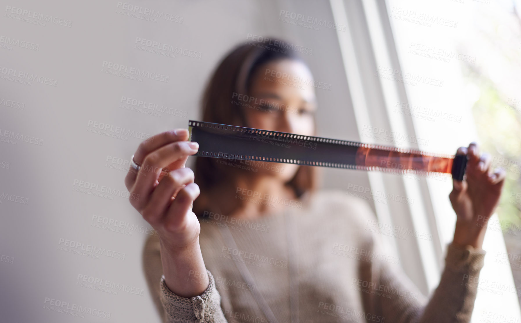 Buy stock photo Woman, photographer and film negative for creative prints at window for sun or retro images for job, inspiration or hobby. Female person, artistic and roll for picture development, photoshoot or job
