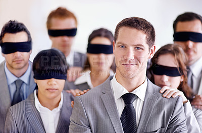 Buy stock photo A young businessman standing in front of a group of blindfolded businesspeople