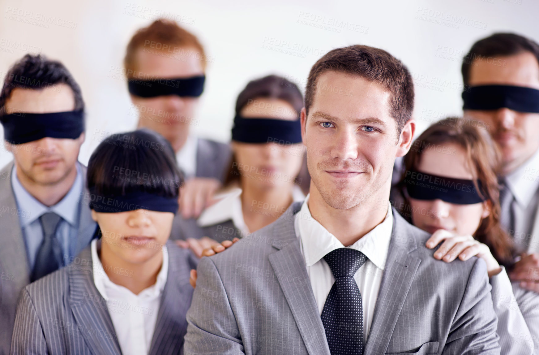 Buy stock photo A young businessman standing in front of a group of blindfolded businesspeople