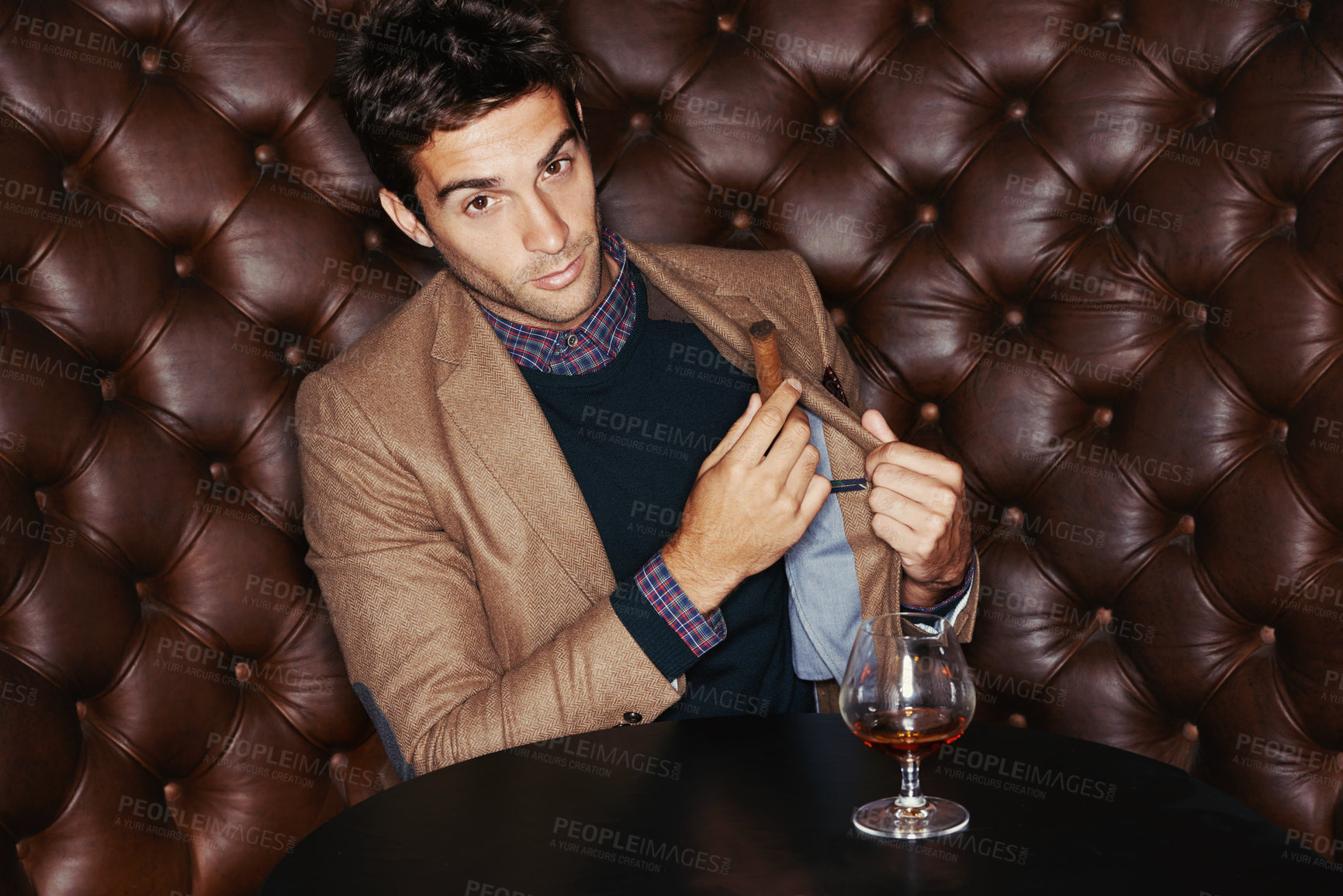 Buy stock photo Portrait, cigar and businessman smoking at pub, fashion and serious person in a suit with alcohol at vintage bar. Face, mafia and drinking whiskey, scotch and brandy in a glass for luxury at club