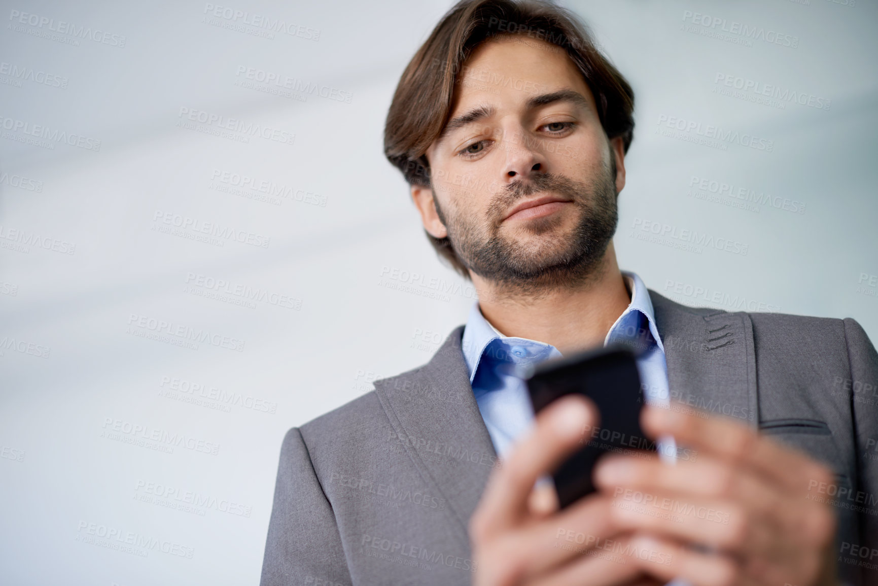 Buy stock photo Businessman, communication and phone for networking in office, social media and app for web. Male person, low angle and searching on internet for opportunity in career, reading notification and news