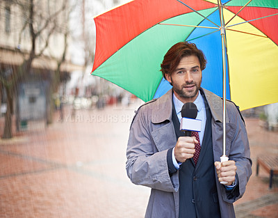 Buy stock photo A smiling weatherman reporting from an urban area