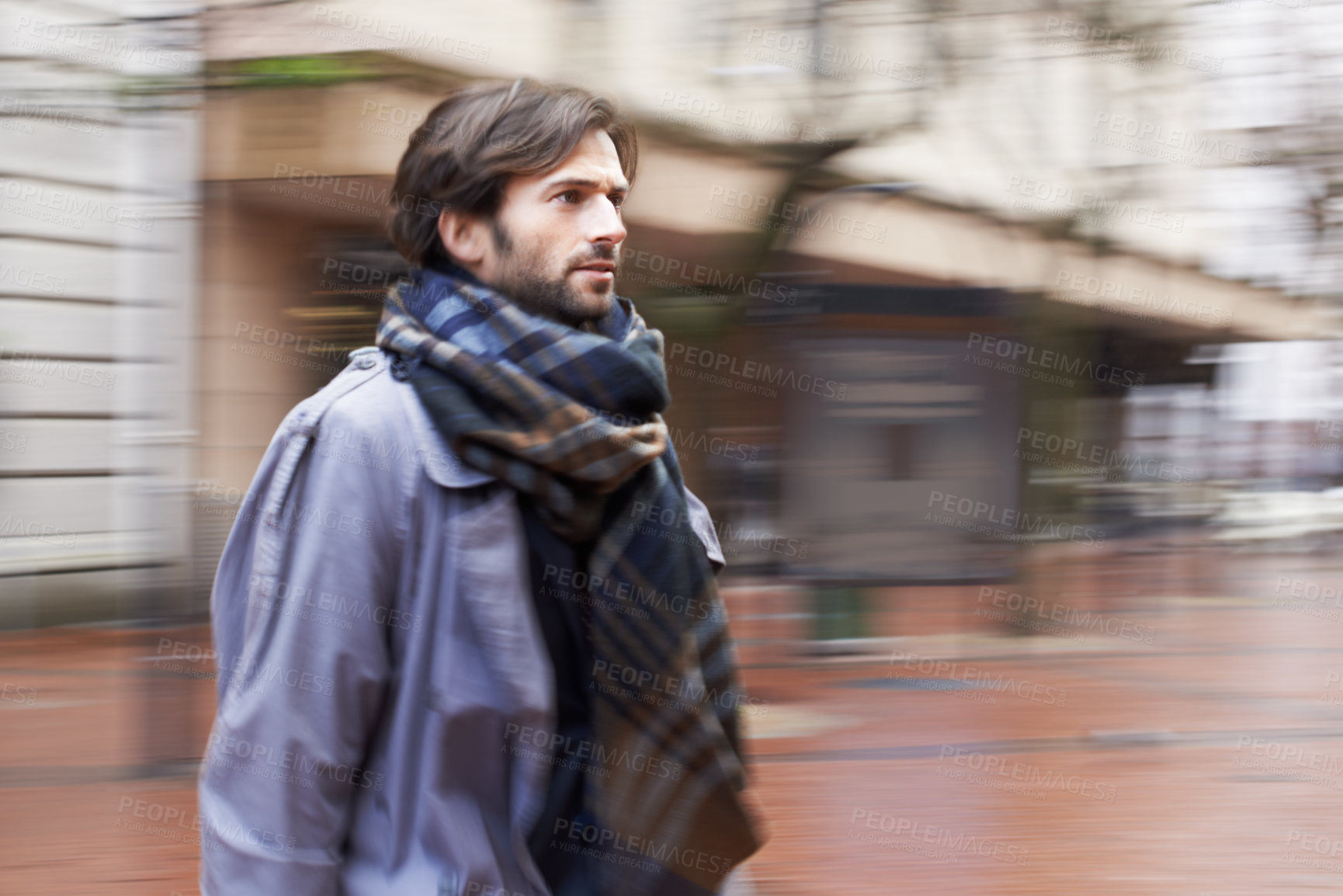 Buy stock photo A handsome man walking through an urban area in a hurry