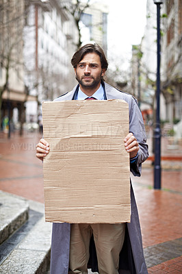 Buy stock photo Sad, business and man with poster, unemployed in city and professional with stress and anxiety. Person, outdoor and financial criss with worker and stock market crash with job loss with recession