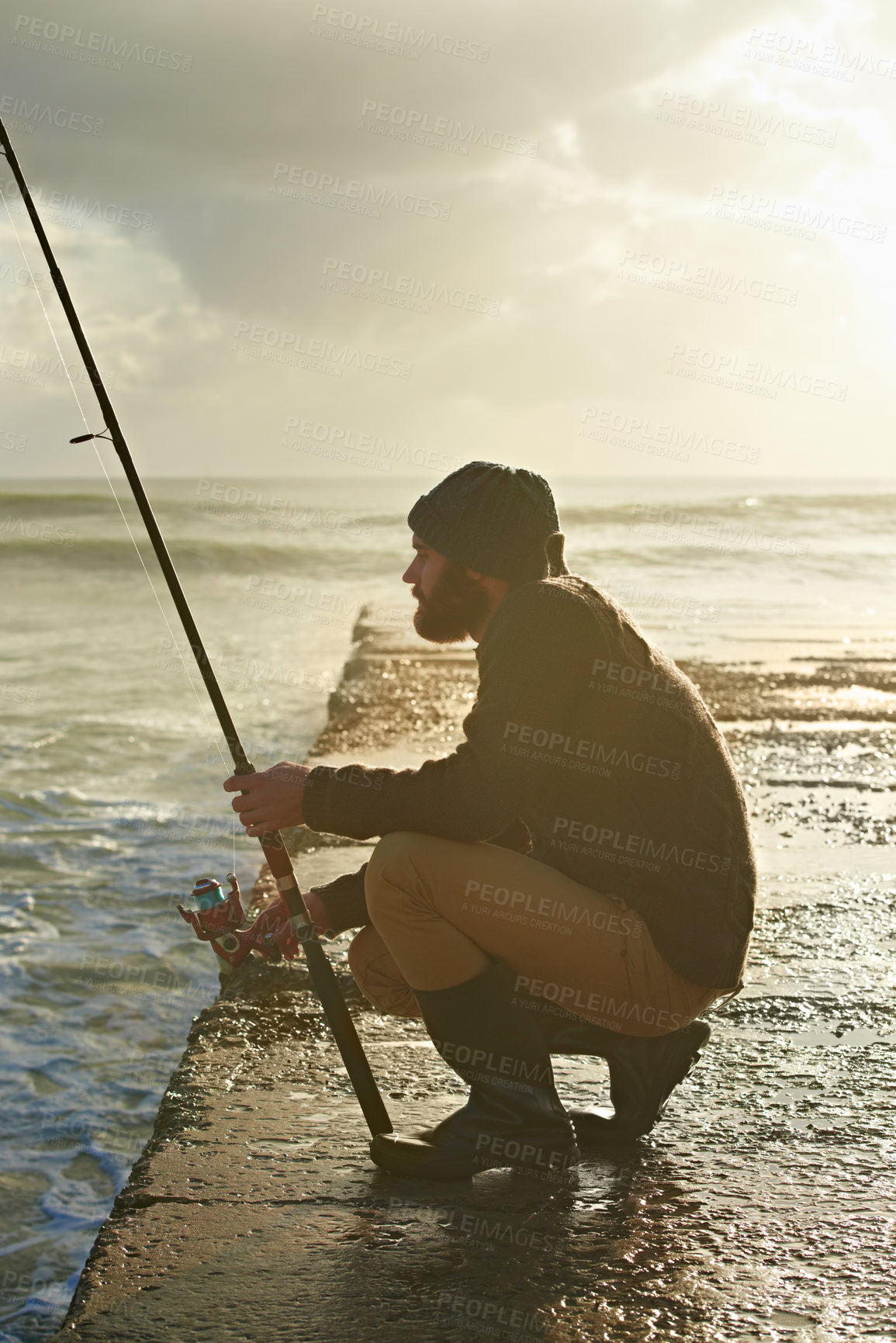 Buy stock photo Man, waiting and fishing on beach in nature, relax and natural sea hobby for wellness on vacation. Fisherman, travel or holiday in cape town by ocean, adventure or patient by hook for fish to bite